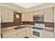 Kitchen featuring tiled backsplash, stainless microwave, double sinks, and white cabinets at 6023 Mayberry Ave, North Port, FL 34287