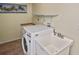 Laundry room featuring front load washer, utility sink, and shelf at 6023 Mayberry Ave, North Port, FL 34287