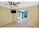 Cozy living room with carpeting, a ceiling fan, and a doorway leading to the sunroom at 6023 Mayberry Ave, North Port, FL 34287