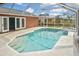 Screened-in pool with attached spa, pool deck and view of home at 6023 Mayberry Ave, North Port, FL 34287