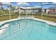 Sparkling pool with spa surrounded by enclosed screen at 6023 Mayberry Ave, North Port, FL 34287