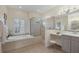 Luxurious bathroom with a soaking tub, glass enclosed shower, and vanity area at 6357 Royal Tern Cir, Lakewood Ranch, FL 34202