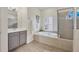 Bathroom featuring a soaking tub, walk-in shower, vanity, and shuttered windows at 6357 Royal Tern Cir, Lakewood Ranch, FL 34202