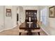 Elegant dining room with dark wood table, decorative hutch, and shuttered windows at 6357 Royal Tern Cir, Lakewood Ranch, FL 34202