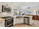 Beautiful kitchen with stainless steel appliances, a farmhouse sink, and white cabinets and backsplash at 6357 Royal Tern Cir, Lakewood Ranch, FL 34202