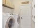 Clean laundry room with a washer, dryer, storage cabinets, and shelving at 6357 Royal Tern Cir, Lakewood Ranch, FL 34202
