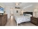 Bright bedroom with a ceiling fan, hardwood floors, and a decorative headboard at 6357 Royal Tern Cir, Lakewood Ranch, FL 34202