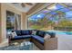 Enclosed patio area boasts a blue cushioned couch, glass table and view of the pool at 6357 Royal Tern Cir, Lakewood Ranch, FL 34202