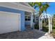 Charming blue home exterior featuring a garage and a decorative white arbor leading to the front entrance at 709 N Bay Blvd, Anna Maria, FL 34216