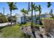 Beautiful blue home exterior featuring an archway, lush landscaping, and well-maintained lawn at 709 N Bay Blvd, Anna Maria, FL 34216