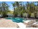 Backyard pool featuring tropical foliage and two lounge chairs on the patio at 709 N Bay Blvd, Anna Maria, FL 34216