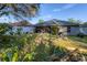 Scenic backyard with a fire pit, lush greenery, and view of the home's patio at 7135 Royal George Ct, Wesley Chapel, FL 33545