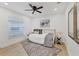 Comfortable bedroom featuring hardwood floors, a ceiling fan, and a large window at 7135 Royal George Ct, Wesley Chapel, FL 33545