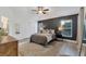Bedroom with dark accent wall, ceiling fan, hard wood floors, and windows with blinds at 7135 Royal George Ct, Wesley Chapel, FL 33545