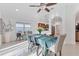 Bright dining room featuring ceiling fan, dining table, and open view to the kitchen at 7135 Royal George Ct, Wesley Chapel, FL 33545