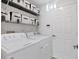 Well-organized laundry room featuring a Whirlpool washer and dryer and storage shelves with labeled bins at 7135 Royal George Ct, Wesley Chapel, FL 33545