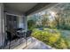 Cozy covered patio with outdoor seating, overlooking the backyard and fire pit area at 7135 Royal George Ct, Wesley Chapel, FL 33545