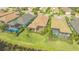 Aerial view of homes showcasing screened-in patios, lush landscaping, and community lake at 7213 Whittlebury Trl, Lakewood Ranch, FL 34202