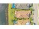 An aerial view showing a well-maintained home with a clay tile roof, lush lawn, and a screened-in patio at 7213 Whittlebury Trl, Lakewood Ranch, FL 34202