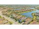 Aerial view of a lakeside community with lush greenery and a golf course in the distance at 7213 Whittlebury Trl, Lakewood Ranch, FL 34202