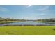 Expansive backyard with a serene lake, well-manicured lawn, and beautiful landscaping at 7213 Whittlebury Trl, Lakewood Ranch, FL 34202