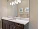 This well-lit bathroom offers a white countertop, dark wood cabinets, and a large mirror at 7213 Whittlebury Trl, Lakewood Ranch, FL 34202