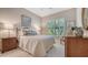 Inviting bedroom showcasing shuttered windows, neutral walls, and a cozy iron bed frame at 7213 Whittlebury Trl, Lakewood Ranch, FL 34202