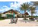 Outdoor seating area featuring a table and chairs, surrounded by mature landscaping and an inviting building facade at 7213 Whittlebury Trl, Bradenton, FL 34202