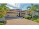 Charming single-story home with a three-car garage, tile roof, and colorful front yard plants at 7213 Whittlebury Trl, Lakewood Ranch, FL 34202