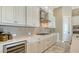 Bright kitchen featuring white cabinets, stainless steel appliances, and stylish backsplash and flooring at 7213 Whittlebury Trl, Lakewood Ranch, FL 34202