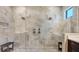 The luxurious glass shower features dual shower heads, marble tile, and a built-in bench at 7213 Whittlebury Trl, Lakewood Ranch, FL 34202