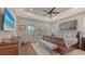 Serene main bedroom with wood floors, tray ceiling, plantation shutters, and a large bed at 7213 Whittlebury Trl, Bradenton, FL 34202