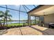 Screened patio with stone fireplace, ceiling fan, and lake view offers a comfortable outdoor living space at 7213 Whittlebury Trl, Lakewood Ranch, FL 34202