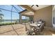 Expansive outdoor living area with a lake view, dining set, and cozy fireplace lounge at 7213 Whittlebury Trl, Lakewood Ranch, FL 34202