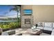 Cozy outdoor living space with stone fireplace, comfortable seating, and scenic lake views at 7213 Whittlebury Trl, Lakewood Ranch, FL 34202