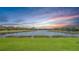Picturesque view of a tranquil pond surrounded by well-maintained lawns and luxurious homes at 7213 Whittlebury Trl, Lakewood Ranch, FL 34202