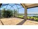Spacious screened lanai with brick flooring, stone pillar, and views of the lush landscaping and lake at 7213 Whittlebury Trl, Lakewood Ranch, FL 34202