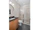 Modern bathroom with granite sink, round mirror, and glass enclosed tiled shower at 7317 Emma Rd, Bradenton, FL 34209