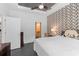 Bedroom with decorative accent wall, ceiling fan and access to the Primary bath and walk-in closet at 7317 Emma Rd, Bradenton, FL 34209