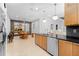 Open-concept kitchen with dark countertops, wood cabinetry, and a view of the dining area at 7317 Emma Rd, Bradenton, FL 34209