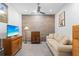 Comfortable living room boasts a rustic wood accent wall, neutral couch, and a large television for entertainment at 7317 Emma Rd, Bradenton, FL 34209