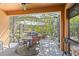 Screened-in patio with umbrella-covered dining set, offering a relaxing outdoor space surrounded by lush greenery at 7317 Emma Rd, Bradenton, FL 34209