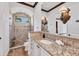 Bathroom featuring granite counters, wood cabinets, a frameless shower, and a view of the outside at 7327 Greystone St, Lakewood Ranch, FL 34202