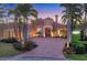 Elegant home featuring lush landscaping, a brick driveway, and barrel tile roof at 7327 Greystone St, Lakewood Ranch, FL 34202
