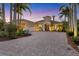 Elegant home features a brick paver driveway, lush landscaping, and a two-car garage at 7327 Greystone St, Lakewood Ranch, FL 34202