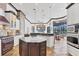 Gourmet kitchen featuring a center island with granite, white cabinets, and brick oven at 7327 Greystone St, Lakewood Ranch, FL 34202