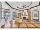 Elegant living room with a stone fireplace, custom floors, and views of the outdoor living area at 7327 Greystone St, Lakewood Ranch, FL 34202