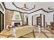 Open living room with stone fireplace, custom floors, and decorative columns leading to other living spaces at 7327 Greystone St, Lakewood Ranch, FL 34202