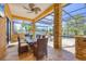 Elegant outdoor dining space featuring a stone table, seating for six, and serene views of the pool and waterfront at 7327 Greystone St, Lakewood Ranch, FL 34202