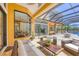 Inviting outdoor living area with comfortable seating, covered patio, and views of the pool and tranquil waterfront at 7327 Greystone St, Lakewood Ranch, FL 34202